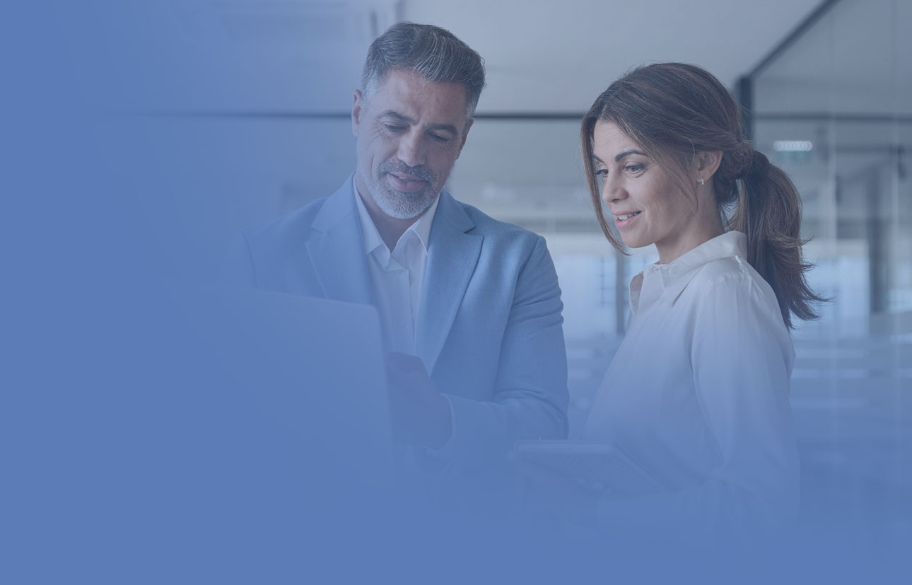 A consultant and an executive talking in front of a laptop